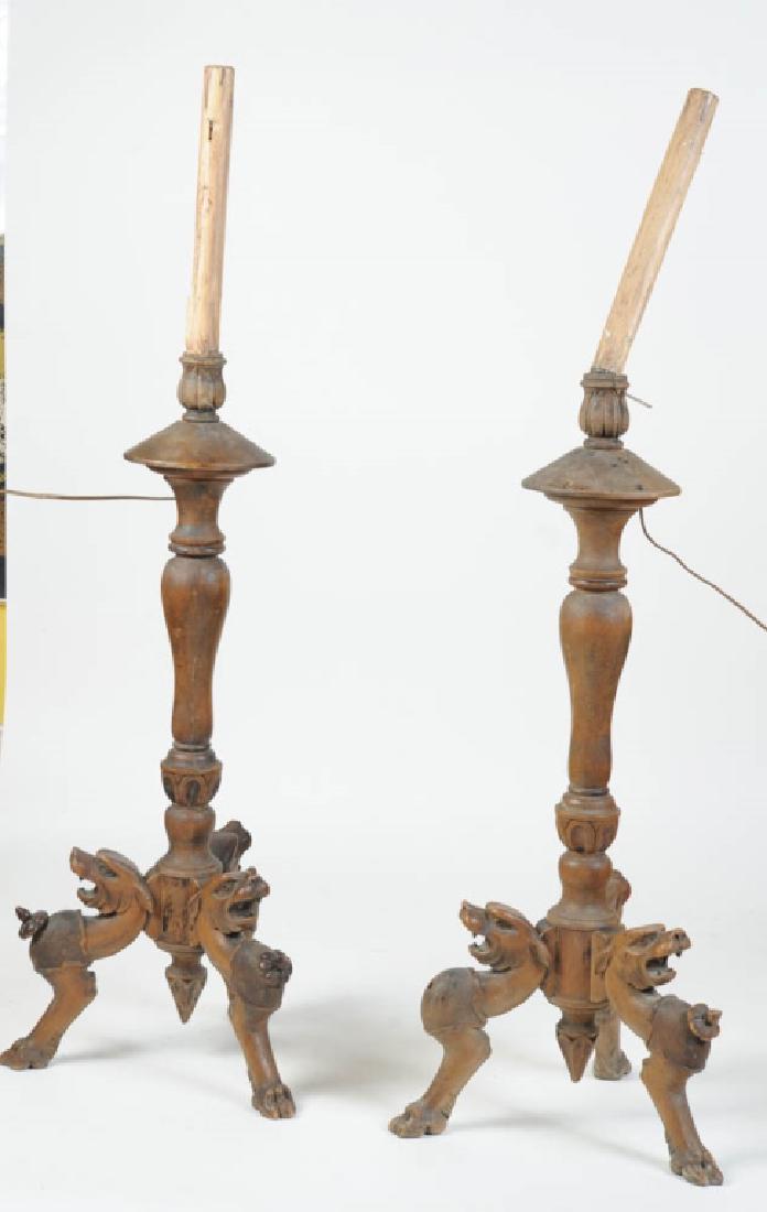 Pair Renaissance Revival Altar Candlesticks: Large continental carved wooden altar candlesticks. Tripod lion head & paw feet. Probably 19th century, electrified circa 1931, according to the newspaper used to line the 'candles'. Candlesticks with