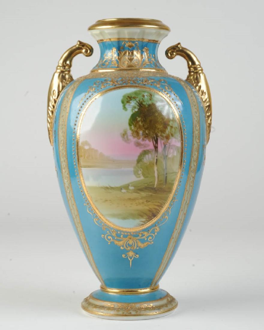 Hand Painted Nippon Scenic Vase: Urn with blue ground with gilt and beaded decorations, riverside landscape with swans one one side and distant boats on the other, marked to base. H: approx. 13 3/4".