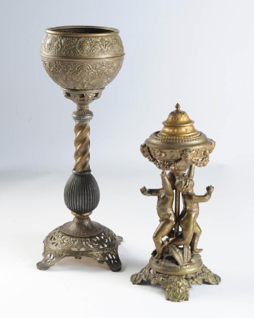 Early Bradley & Hubbard Oil Lamp + Cherub Lamp: Circa 1870s / 80s brass and iron Bradley & Hubbard oil lamp base marked B & H 3122, together with an unmarked weighted brass or bronze cherub lamp base. Tallest: approx. 19".