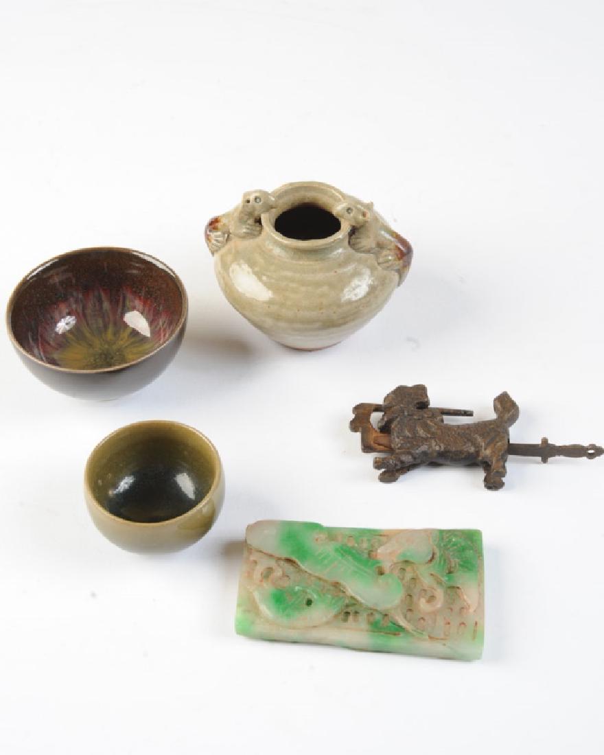 Lot of Chinese Decorative Objects: Including a carved jade or hardstone pendant ornament, a small Yuan dynasty type longquan celadon jarlet, a bronze lock in the form of a mythical beast, and two small glazed pottery cups.