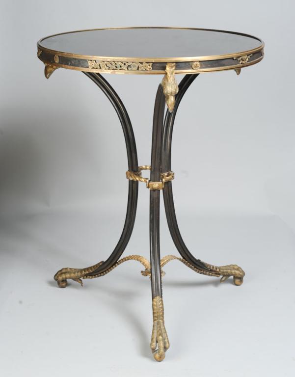 Neoclassical Style Painted Metal Gueridon Table: With polished granite insert, brass eagle mounts, accents, and stretcher, tripod legs, crossed stretcher and talon feet. H: approx. 28". Dia: approx. 21 1/2".