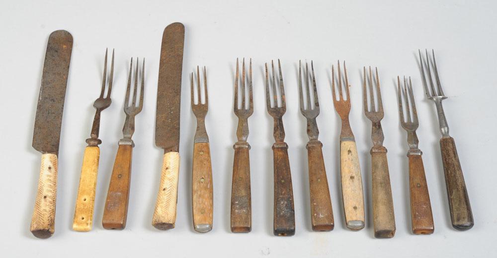 18th & 19th C. Wood & Bone Handled Steel Cutlery: Two 19th C. knives with carved bone or antler handles marked John Kirk & Sons, Sheffield. Seven wooden handled forks, three bone or antler handled forks. Some tines broken, some rust, much wear. Twelv