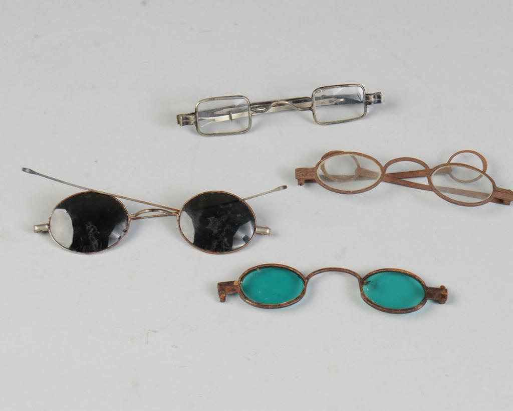 Lot 18th & 19th C. Eyeglasses, Sunglasses: To include late 18th C. eyeglasses with square frames, 18th C. eyeglasses with round frames and round ear pieces, and two pairs of tinted sunglasses, probably 19th c, one with turquoise blue glass, st