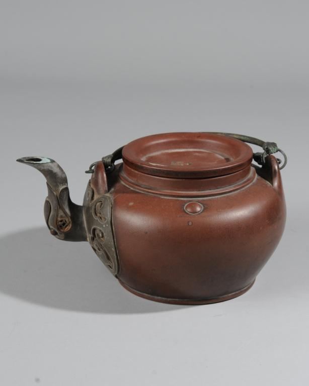 Antique Chinese Yixing Teapot: With good darkened patina matched by old tea residue to interior. Impressed marks to cover and base. Pewter bail handles and elephant head spout with excellent dark patina. Approx. 4 1/2" in height (e