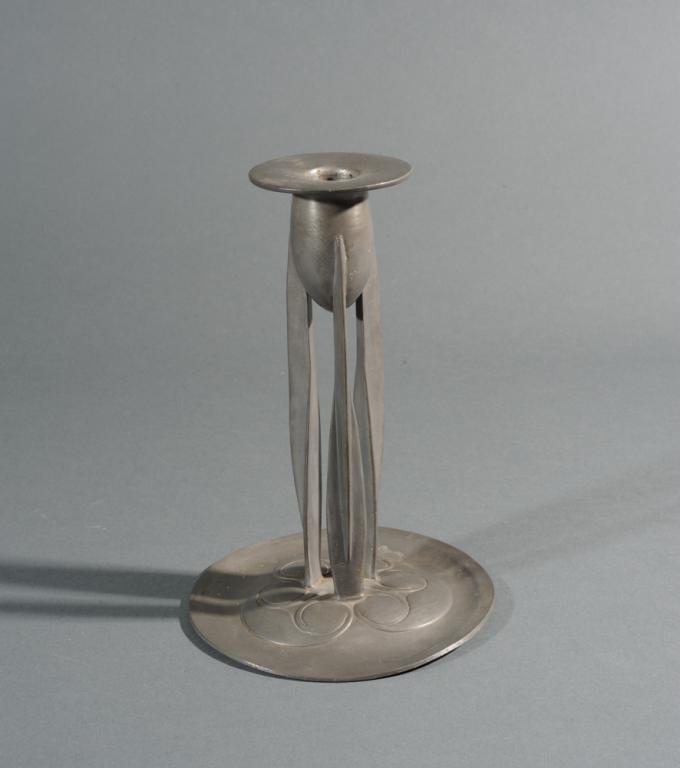 Knox Tudric Pewter Arts & Crafts Candlestick: Designed by Archibald Knox for Liberty and Co., model 0223, together with a pair of brass candlesticks. Tallest: approx. 8 1/2".