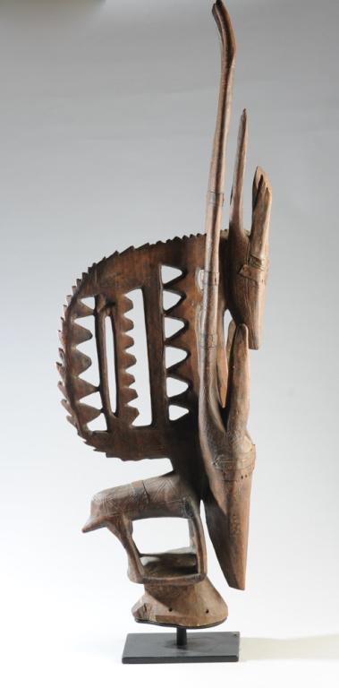 Bambara Chiwara Head Mask, Mali: Carved wooden vertical mask worn on the top of the head, in double antelope form, with metal and incised decoration. Rich warm patina. Collected circa 1960s in Minianka District, Mali. On custom galle