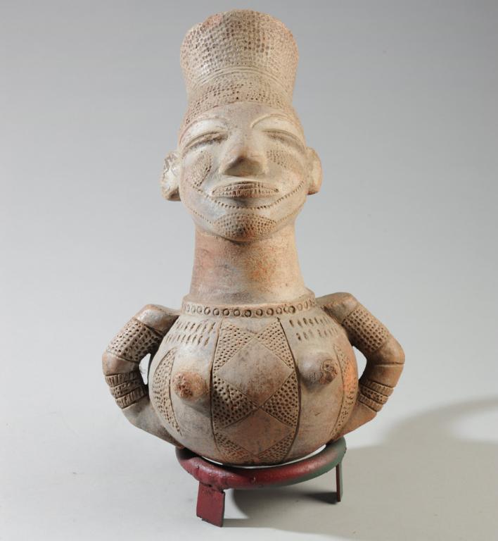 Mangbeto Figural Vessel, DR Congo: Anthropomorphic terracotta vessel for palm wine in the form of a female figure with the elongated head and elaborate coiffure essential to the Mangbeto ideal of female beauty. Mangbeto people, Democra