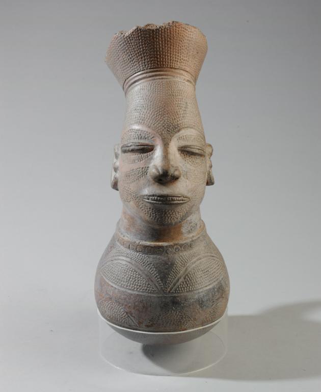Mangbeto Figural Palm Wine Vessel: Anthropomorphic terracotta vessel for palm wine in the form of a female figure with the elongated head and elaborate coiffure essential to the Mangbeto ideal of female beauty. Mangbeto people, Democra