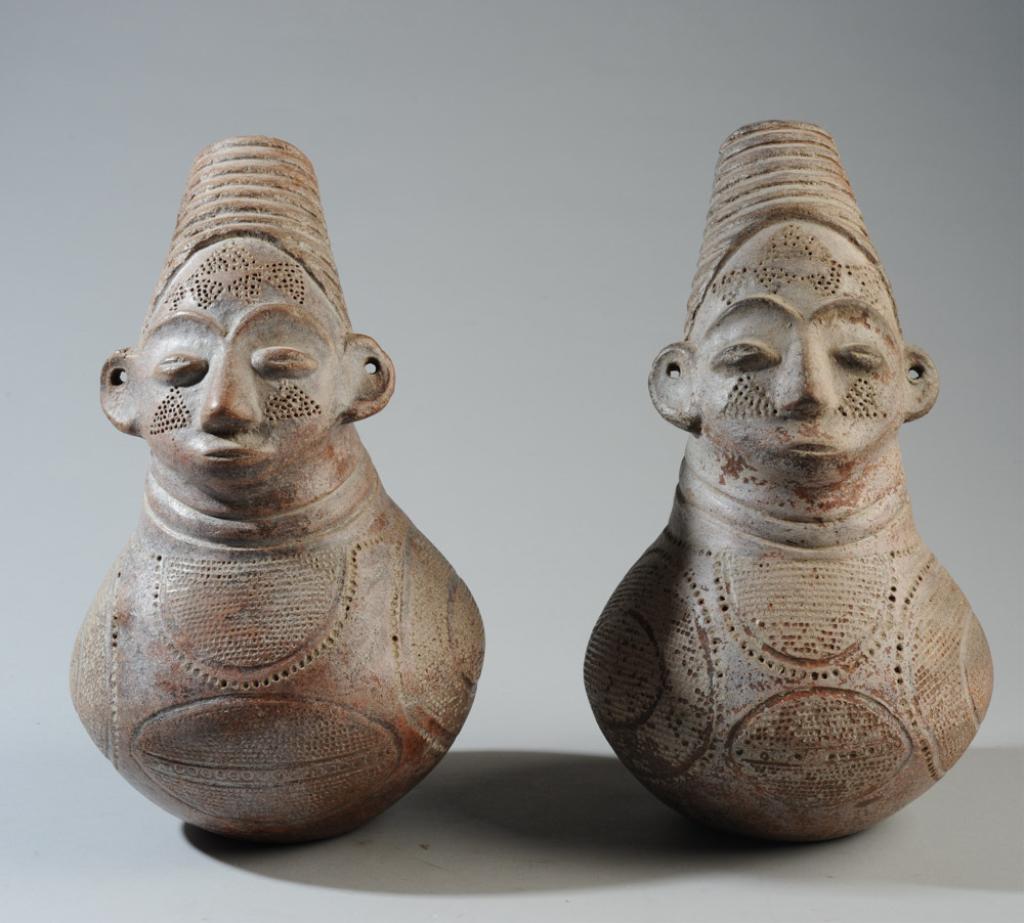 Pair Mangbeto Figural Palm Wine Vessels: Anthropomorphic terracotta vessels for palm wine in the form of female figures, with the elongated heads and elaborate coiffures essential to the Mangbeto ideal of female beauty. Mangbeto people, Demo