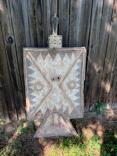 Toussian Loniake Mask: Plank mask of avian form, carved wood with rope, animal hide, glass, beads embedded in clay, kaolin and other pigments. Approx. 45" x 22" Provenance: Estate of Thomas McNemar, (1931-2019.) McNemar liv