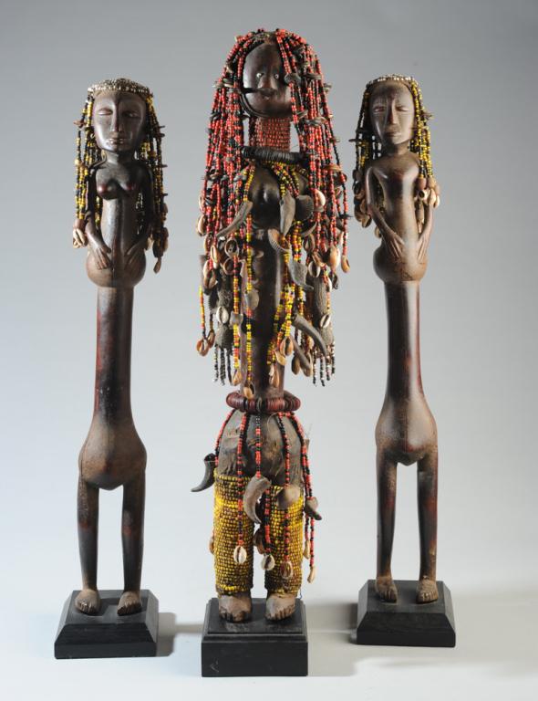 Three Dinka Tribal Dolls, Sudan: Carved wood, beads, buttons, shells, fiber. Each on custom gallery base. Tallest, approx. 25 1/2" H. Provenance: Estate of Thomas McNemar, (1931-2019.) McNemar lived and collected throughout Central a