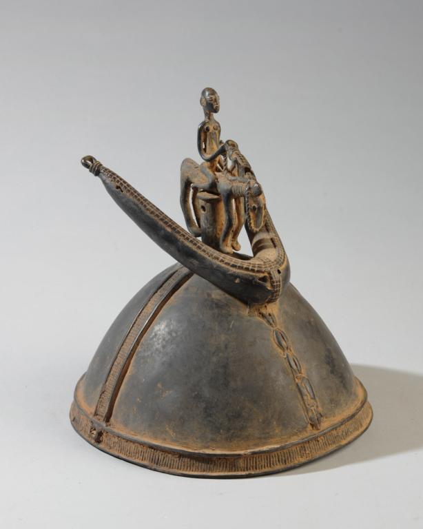 Dogon Kulongo Metal Helmet: Cast metal helmet with equestrian figure, Dogon people, Ivory Coast. Approx. 8 1/2" x 9" x 10" H Provenance: Estate of Thomas McNemar, (1931-2019.) McNemar lived and collected throughout Central and W