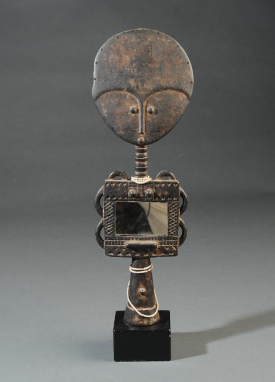 Asante Akua Ba Fertility Figure Ghana: Akua Ba fertility figure of carved wood, with unusual addition of inset mirror. An abstracted image of ideal Asante beauty, the Akua Ba figures are carried wrapped to the back like a real infant, by w
