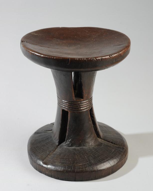Mangbetu Stool, D.R. Congo: Carved wooden stool with waisted, slotted pedestal, smooth lustrous patina. Age cracks. Mangbetu people, D. R. Congo. Approx 10 1/2" in height. Provenance: Estate of Thomas McNemar, (1931-2019.) McNem