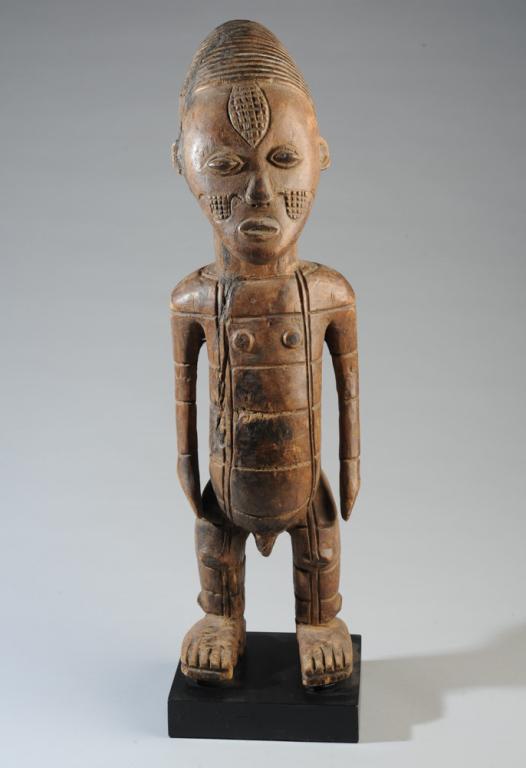 Mangbetu Beli Male Figure: Carved wood standing male figure, with the elongated head and facial scarification consistent with Mangbetu ideals of beauty. Incised linear decoration to body. D. R. Congo. Cracks, old repairs. Appro