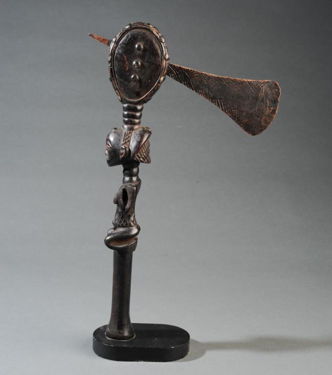 Luba Ceremonial Axe, D. R. Congo: Wood axe handle with carving of seated female figure and embellished with copper strip and tacks, and with copper alloy axe head having incised geometric decoration. The wood with blackened surface. P