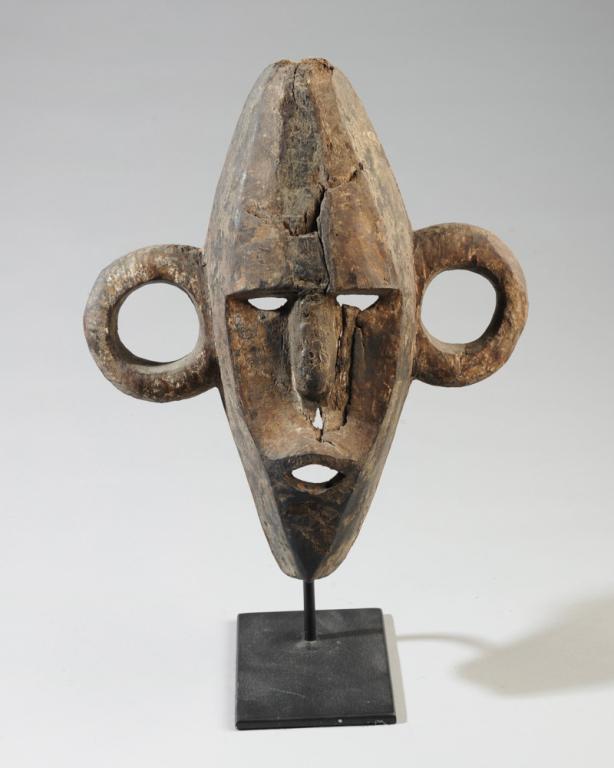 Boa Pongdudu Mask: With characteristic hoop ears. Appears to have age, vestiges of old pigment, complex surface patina. Holes where teeth once were, now lost. Cracks. Baboa people, Democratic Republic of Congo. Approx. 