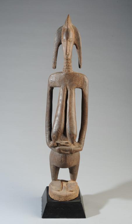 Bamana / Bambara Maternity Figure, Mali: Guandousou carved wood sculpture of a mother breastfeeding her child. The maternal figure has a long, ringed neck, facial and body scarification, a long torso, full breasts and short legs. Sculpture i