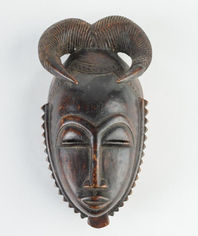 Fine Baule Miniature Mask: Carved wood with traces of kaolin. Baule people, Ivory Coast. Approx. 7 1/2" x 3 1/2". Provenance: Estate of Thomas McNemar, (1931-2019.) McNemar lived and collected throughout Central and West Africa