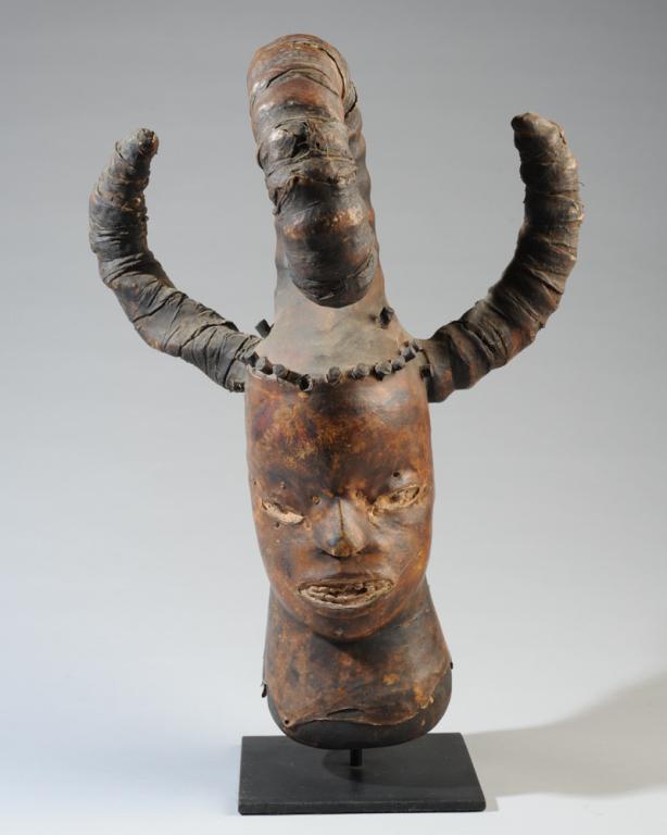 Ekoi Ejagham Skin Head Crest Mask: Animal skin head crest mask with four curling horns. Nigeria. On gallery stand. Crest, approx. 17 1/2" x 13" x 12" Provenance: Estate of Thomas McNemar, (1931-2019.) McNemar lived and collected throug