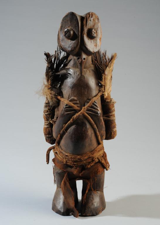 Yaka or Holo Hamba Owl Power Figure: Anthro-zoomorphic figure or masker with owl face or mask and human body, with medicinel bundles wrapped and tied to sides. Carved wood, leather, fabric, feathers, and other material. Yaka or Holo peop