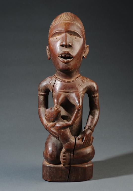 Congo Maternity Figure, Vili, Yombe, Bakongo: Beautifully rendered maternity figure with smooth dark patina, the seated mother nursing her child, the hands of both mother and child expressing tenderness and belonging. Mother with open mouth, care