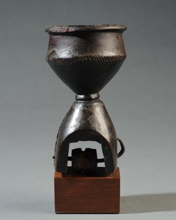 African Heddle Pulley: Carved wood heddle pulley,the finial in the form of a rimmed cup or bowl with subtle incised decoration, beautiful dark oily surface, old staple repair. Mouonted to gallery base. Pulley approx. 5 1/4"