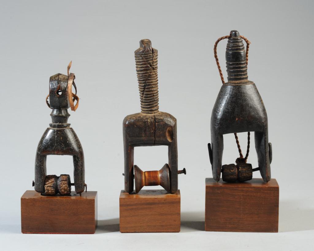 Three West African Heddle Pulleys: All of geometric form, appear worn, all on gallery stands. Pulleys, approx. 5 1/2" to 7" H. Provenance: Estate of Thomas McNemar, (1931-2019.) McNemar lived and collected throughout Central and West A
