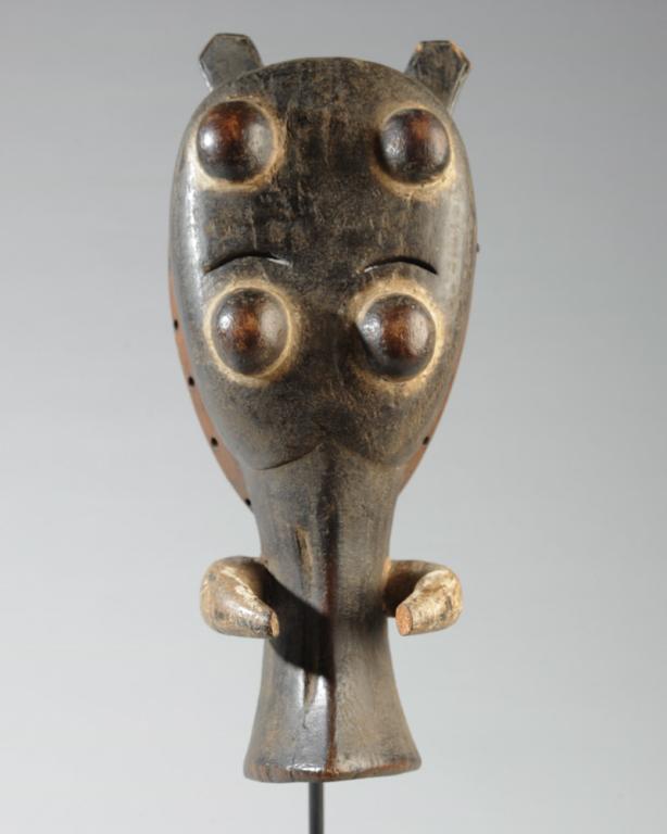 African Zoomorphic Pende Mask: Tusked mask with long snout or trunk, four bulging eyes, small ears. Tip of one tusk missing. On gallery stand. Mask, approx. 14" x 6". Provenance: Estate of Thomas McNemar, (1931-2019.) McNemar lived