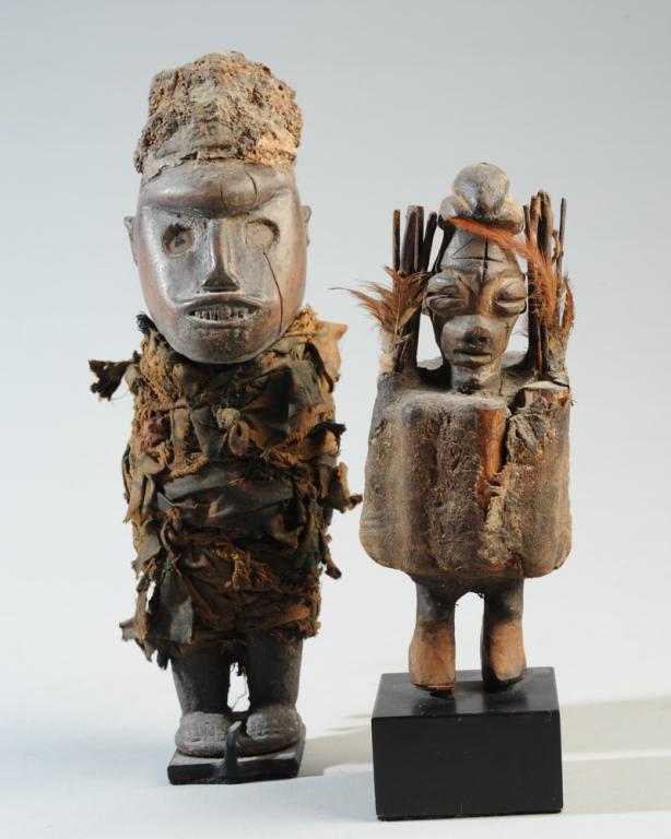 Two African Fetish / Power Figures: The larger probably Kongo, a carved wood figure, the head heavily encrusted with organic material, the body wound in fabric with complex wrapping and knotting. The smaller figure possibly Fon, a woode