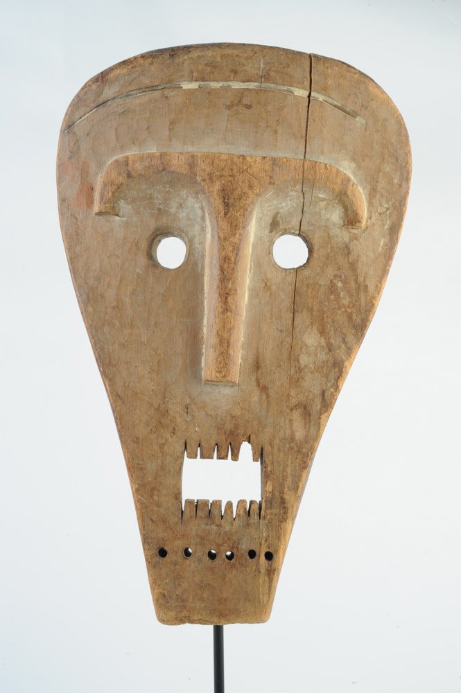 Lega Mask: Carved wood, traces of kaolin. On custom gallery stand. Approx. 15" x 10". Provenance: Estate of Thomas McNemar, (1931-2019.) McNemar lived and collected throughout Central and West Africa in the 1960