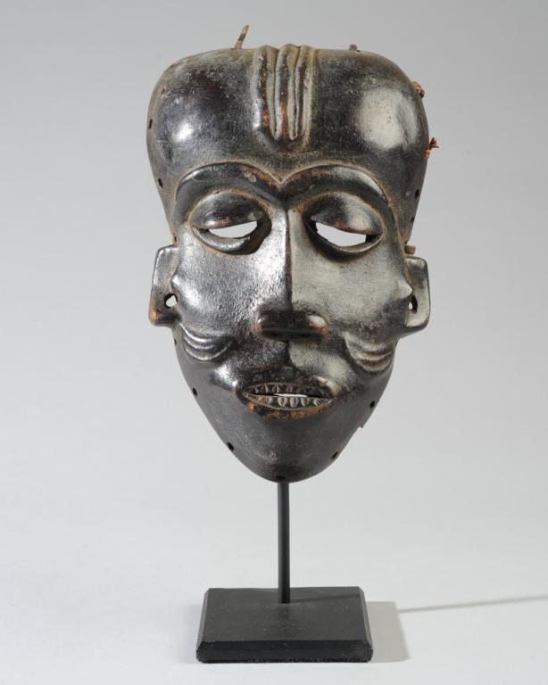 Pende Mbuya Mask, Congo: Of the type worn for initiation ceremonies. Carved wood mask with typical prominent, rounded forehead with central ridges, arched eyebrows, sharply defined cheekbones, the lips parted to reveal small,
