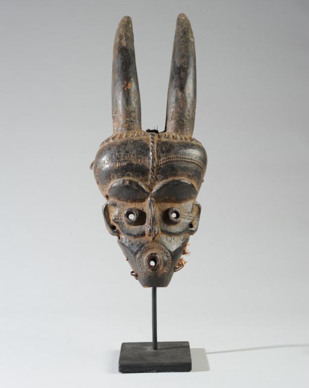 Eastern Pende Giphogo Mask Congo: Delicate carved wood mask with horns, broad and rounded forehead, the eyes and mouth alike carved as protruding tubular circles, with slender nose, finely relief-carved scarification, small ears. D. R
