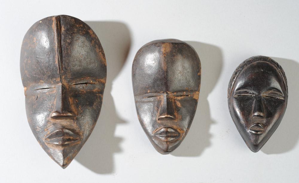 Three Dan Passport Miniature Masks: All of the "deangle" form with attractive features and narrow slit eyes. Sizes, from largest mask to smallest: approx. 6" x 3 1/2", 4 5/8" x 3 3/4", and the smallest approx. 4" x 2 1/2". Provenance: E