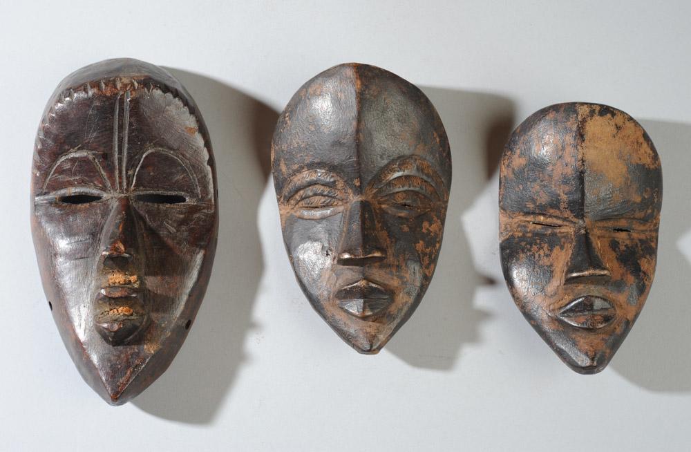 Three Miniature / Passport Masks: Three miniature Dan "deangle" masks, the larger with holes to permit wearing so possibly a small face mask, the smaller two both passport masks. Largest mask, approx. 7" x 3 3/4". Remaining masks 5 1/