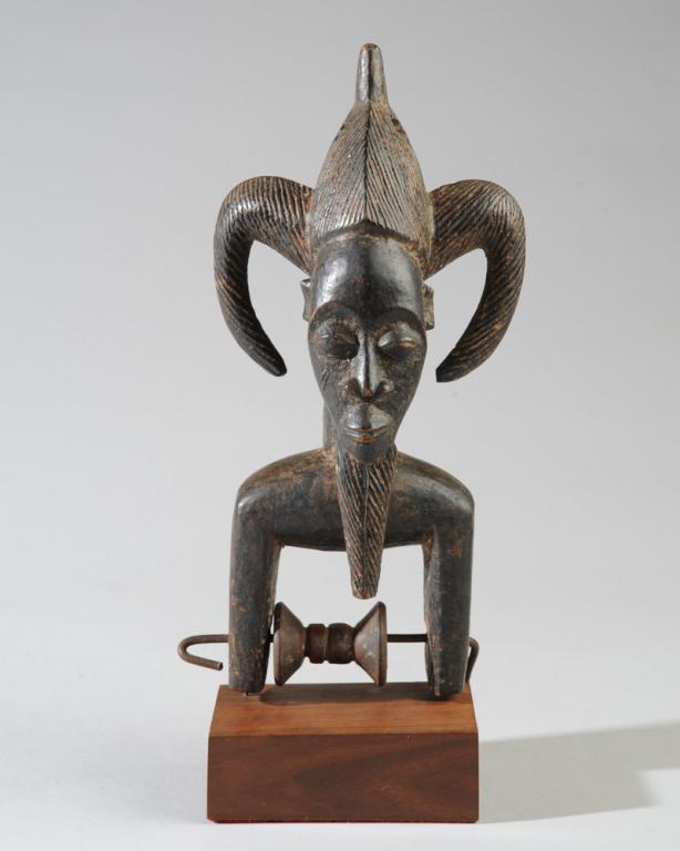 West African Anthropomorphic Heddle Pulley: Probably Baule. Finely carved male head with elaborate three part coiffure and long beard, with pleasing oval face with arched brows, coffee bean eyes, the cheeks with relief-carved chevron scarificat