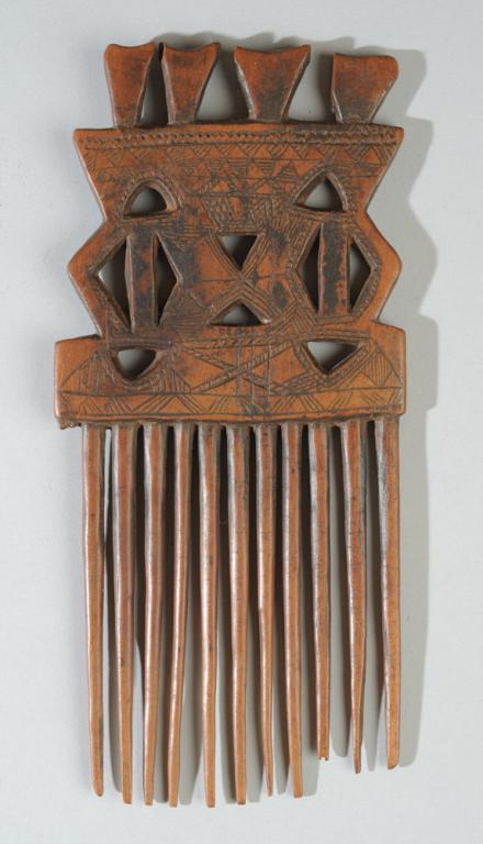 African Fulani Comb, Mali: Beautiful old comb with geometric handle with elaborate incised decoration. Warm, reddish brown wood with good patina. Collected prior to 1966 in the Timboctou region of Mali. Approx. 8 1/2" H. Proven