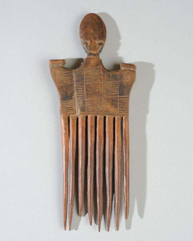 Ashanti African Comb: Body incised with patterned squares reminiscent of Kente cloth, surmounted by oval head with minimalist features. Ashanti people, Ghana. Approx. 8 1/2" H.Provenance: Estate of Thomas McNemar, (1931-20