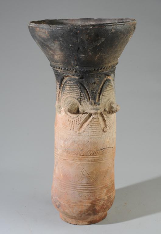 Nupe Terracotta Vessel Support, Nigeria: Nupe pot supports were partially buried in the earth, their flaring mouths made to support stacks of round pots. The blackened upper portion reflects exposure to cooking fires, while the pristine lowe