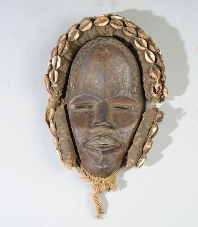 Bronze Dan Mask: Bronze mask with cowrie shells, fabric. Dan people, Liberia / Ivory Coast. Approx. 10" x 7 1/2". Provenance: Estate of Thomas McNemar, (1931-2020.) McNemar lived and collected throughout Central and W