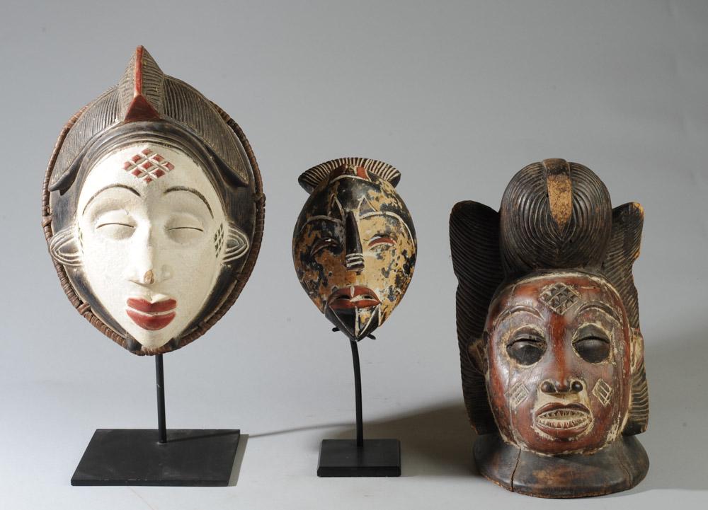 Three Punu Masks: Carved wood female ancestor Okuyi face mask with black, red, green and white pigments and wicker work represents the ideal of Punu feminine beauty. Offered with carved wood Punu Okuyi helmet or crest