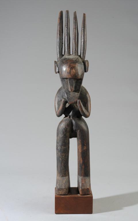 Bamana Standing Figure, Mali: Carved wood standing figure with simplified form, mask head. Dark surface. Approx. 20 1/2" in height, 22 1/2" with gallery stand. Provenance: Estate of Thomas McNemar, (1931-2020.) McNemar lived and c