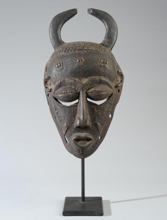African Chokwe Mask: Appears to be an old or antique mask with horns, large bulging closed eyes, small highly placed ears, beautiful relief carved details. Shows wear and use. On gallery stand. Approx. 13 1/2" x 7".Proven