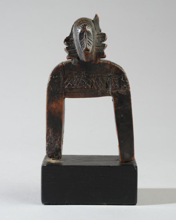 Senufo Kpelie Masker Heddle Pulley: Carved wood heddle pulley with head of a Kpelie masked dancer, the edge of the mask clearly carved so that the human face beneath is vividly suggested. Old losses, old repairs. Mounted to custom galle