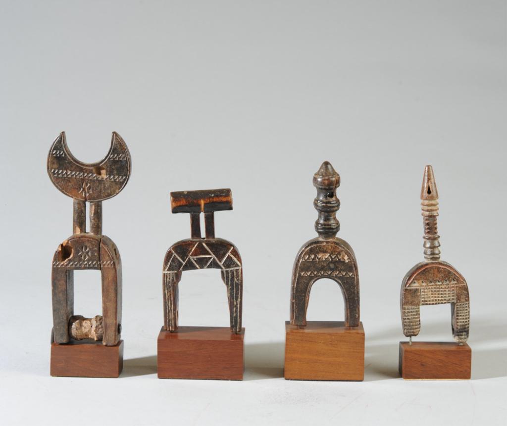 Four African Heddle Pulleys: All of geometric form, possibly abstract animal or human figures, with raised and incised decoration. The pulley with crescent shaped finial shows old insect damage, old split. Heights of pulleys, app