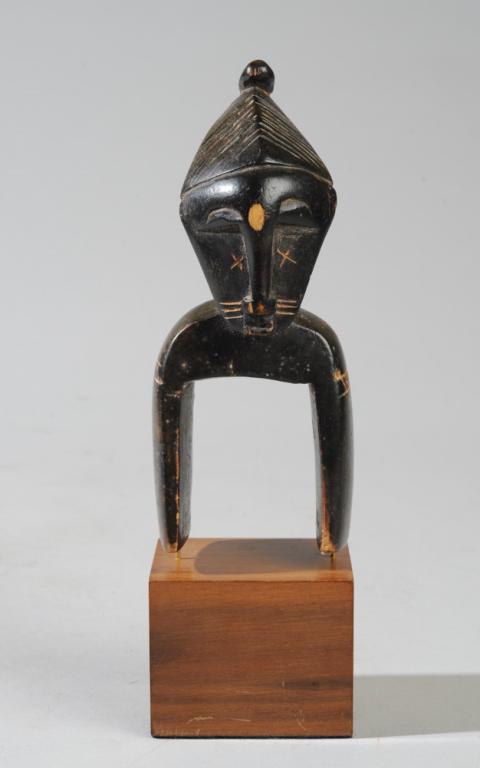 West African Heddle Pulley: Anthropomorphic pulley with mask like face on long curved neck, long slender nose, arched eyebrows, incised facial scarification, high tapering coiffure with knobbed end. On custom gallery base. Heigh