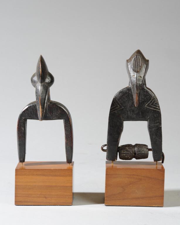 Two Senufo Heddle Pulleys: Both of avian form, with crested heads and long curved beaks. One has extensive incised detail. Both on custom gallery bases. Pulleys, approx. 6 1/4" H. Provenance: Estate of Thomas McNemar, (1931-202
