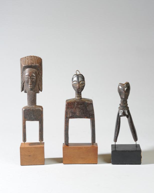 Three African Figural Heddle Pulleys: The largest a janiform pulley, the opposing faces sharing a carefully carved wedge shaped coiffure, both faces expressing idealized beauty with their oval form, arched brows, delicate nose and pouting