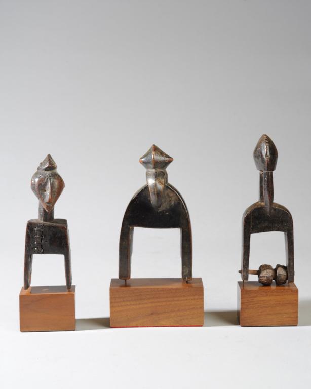 Three Senufo Heddle Pulleys: Two birdlike pulleys with crested heads and long beaks, the third an anthropomorphic pulley, the head with crested coiffure and pointed, beaklike chin. This last pulley with old staple repairs, old lo