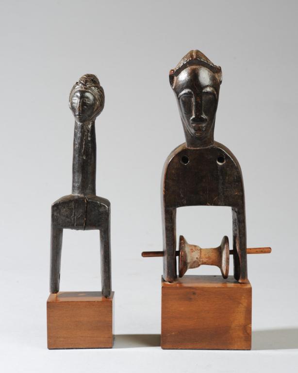 Two Figural African Heddle Pulleys: Of anthropomorphic form, one with small head with complex coiffure on long cylindrical neck, the other with somewhat flattened face, high set ears, and well-carved coiffure. Pulleys approx. 7 1/2" and